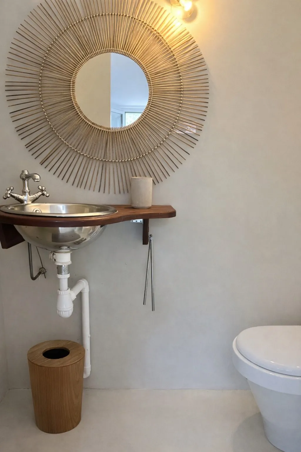 Salle d'eau de la Chambre Cosy : miroir soleil en rotin au-dessus du lavabo